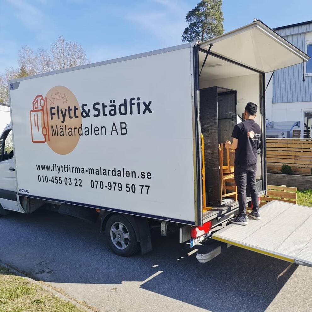 Flyttgubbe lastar på lastbilsflak