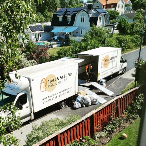 Pågående lastning på två lastbilar utanför bostad