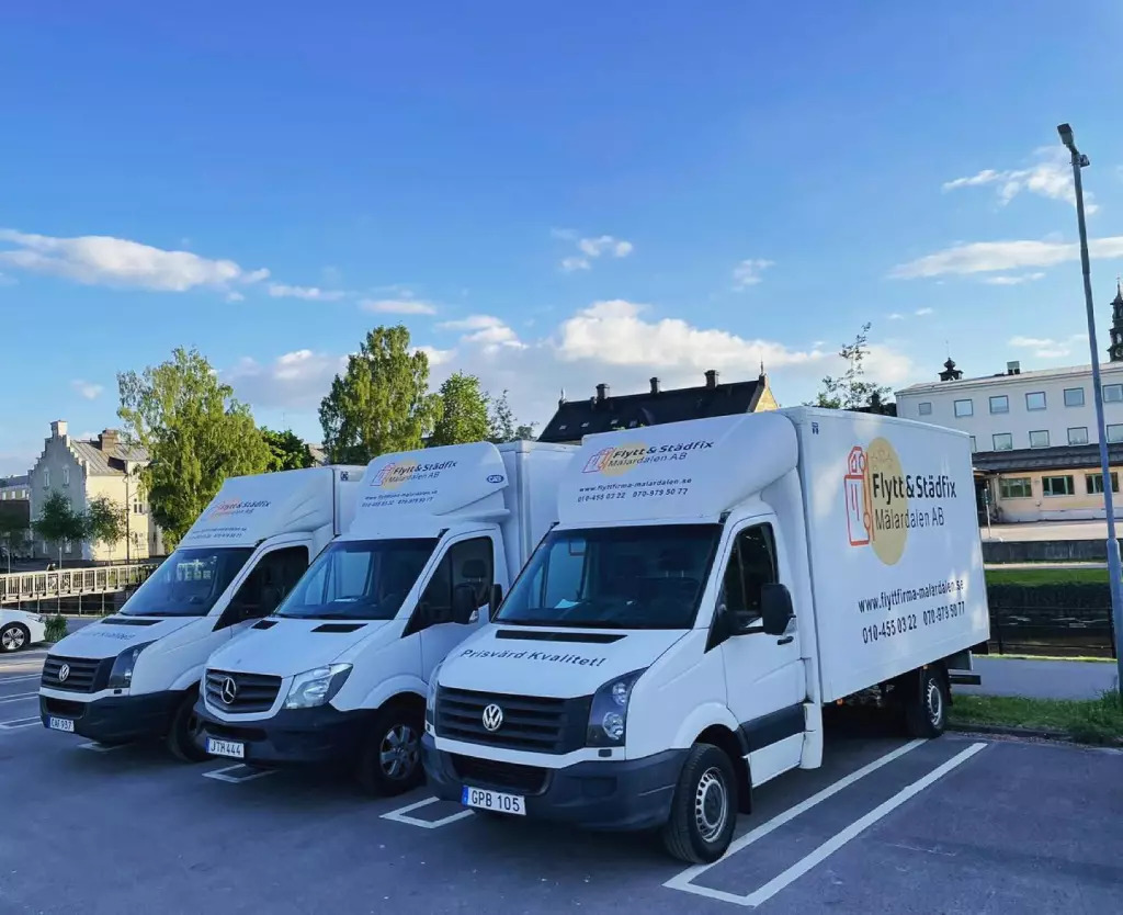 Tre flyttbilar parkerade på parkeringsplats