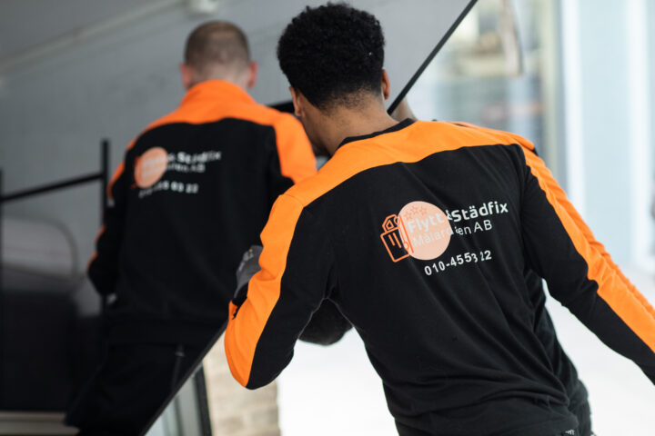A member of the Flytt och Städfix Mälardalen AB team moving a large TV during a move.